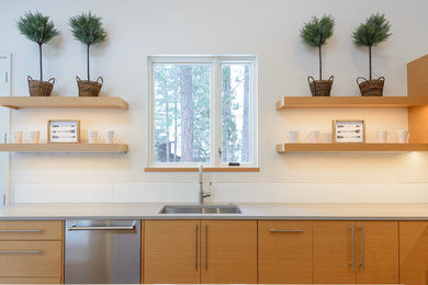 他の地域にあるコンテンポラリースタイルのおしゃれなキッチン (フラットパネル扉のキャビネット、中間色木目調キャビネット) の写真