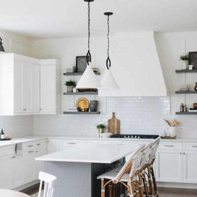 Inspiration for a transitional l-shaped dark wood floor and brown floor eat-in kitchen remodel in Chicago with shaker cabinets, white cabinets, white backsplash, subway tile backsplash, an island and white countertops