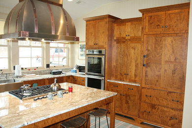 Example of a mountain style l-shaped eat-in kitchen design in Cincinnati with a farmhouse sink, shaker cabinets, medium tone wood cabinets, granite countertops and stainless steel appliances