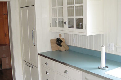Diseño de cocina vintage con fregadero encastrado, armarios con paneles lisos, puertas de armario blancas, encimera de laminado y suelo de linóleo