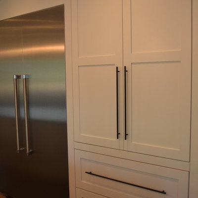 Inspiration for a mid-sized farmhouse u-shaped medium tone wood floor and brown floor eat-in kitchen remodel in Denver with shaker cabinets, white cabinets, brown countertops, a farmhouse sink, white backsplash, glass tile backsplash, stainless steel appliances and concrete countertops