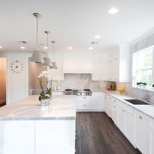 Example of a large transitional u-shaped porcelain tile and brown floor kitchen design in Miami with a drop-in sink, white cabinets, marble countertops, multicolored backsplash, stone slab backsplash, stainless steel appliances, an island, shaker cabinets and gray countertops