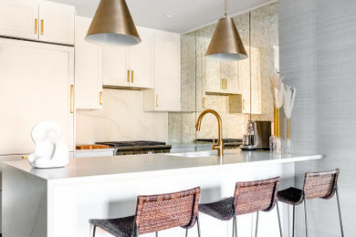 Inspiration for a contemporary light wood floor and beige floor open concept kitchen remodel in New York with a drop-in sink, shaker cabinets, white cabinets, marble countertops, white backsplash, mirror backsplash, stainless steel appliances, an island and white countertops