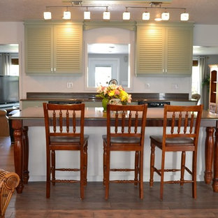 Design ideas for a mid-sized beach style l-shaped eat-in kitchen in Orlando with a double-bowl sink, louvered cabinets, green cabinets, stainless steel appliances and with island.