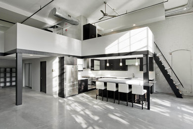 Example of a mid-sized minimalist l-shaped concrete floor open concept kitchen design in Boston with an undermount sink, flat-panel cabinets, dark wood cabinets, solid surface countertops, white backsplash, ceramic backsplash, stainless steel appliances and an island