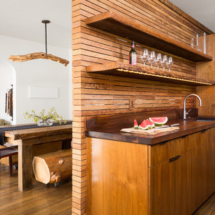Ispirazione per una piccola cucina design con lavello sottopiano, ante lisce, ante in legno bruno, top in legno, elettrodomestici da incasso, paraspruzzi marrone, paraspruzzi in legno, pavimento in legno massello medio, nessuna isola e pavimento marrone