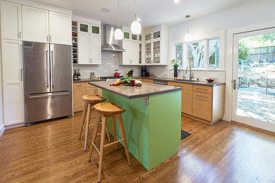 Inspiration for a mid-sized eclectic l-shaped medium tone wood floor and brown floor eat-in kitchen remodel in San Francisco with an undermount sink, flat-panel cabinets, light wood cabinets, quartz countertops, white backsplash, ceramic backsplash, stainless steel appliances, an island and gray countertops