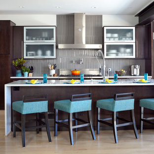 Immagine di una cucina parallela design con ante lisce, ante in legno bruno, paraspruzzi grigio, parquet chiaro e isola