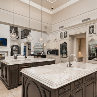 Expansive mediterranean u-shaped separate kitchen in Phoenix with an undermount sink, recessed-panel cabinets, dark wood cabinets, quartzite benchtops, multi-coloured splashback, porcelain splashback, stainless steel appliances, porcelain floors, multiple islands, multi-coloured floor and beige benchtop.