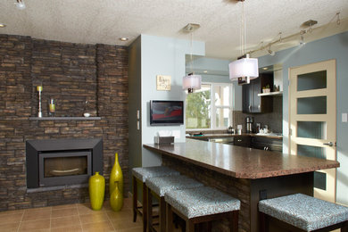 Minimalist eat-in kitchen photo in Calgary with dark wood cabinets, mosaic tile backsplash and stainless steel appliances