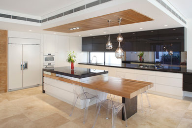 Ejemplo de cocina contemporánea con armarios con paneles lisos, puertas de armario blancas, suelo de travertino, una isla y electrodomésticos con paneles