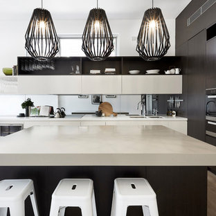 Mid-sized contemporary l-shaped open plan kitchen in Sydney with with island, a double-bowl sink, flat-panel cabinets, dark wood cabinets, mirror splashback, stainless steel appliances and beige benchtop.