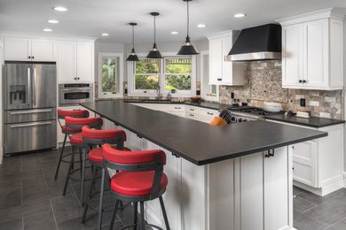 Transitional gray floor kitchen photo in Charlotte with shaker cabinets, stainless steel appliances, an island and black countertops