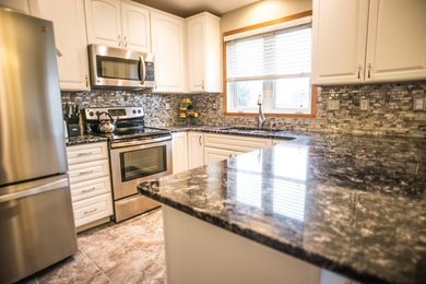 Mid-sized transitional ceramic tile enclosed kitchen photo in Other with raised-panel cabinets, white cabinets, granite countertops, stainless steel appliances, a peninsula, a double-bowl sink, multicolored backsplash and matchstick tile backsplash