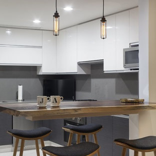 This is an example of a small modern u-shaped eat-in kitchen in Other with a drop-in sink, louvered cabinets, white cabinets, onyx benchtops, grey splashback, stainless steel appliances, marble floors and with island.