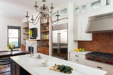 Mid-sized elegant l-shaped medium tone wood floor eat-in kitchen photo in Boston with an undermount sink, shaker cabinets, white cabinets, red backsplash, stainless steel appliances, an island and limestone countertops