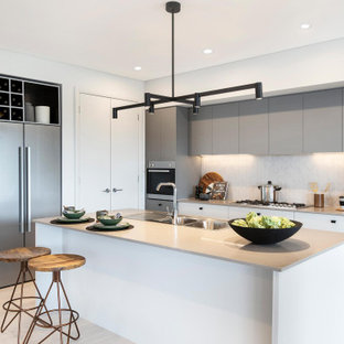 Inspiration for a large contemporary open plan kitchen in Wollongong with a double-bowl sink, shaker cabinets, grey cabinets, quartz benchtops, grey splashback, ceramic splashback, stainless steel appliances, cement tiles, with island, grey floor and grey benchtop.