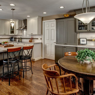 Traditional eat-in kitchen inspiration - Example of a classic u-shaped eat-in kitchen design in Seattle with a drop-in sink, shaker cabinets, white cabinets, laminate countertops, white backsplash, ceramic backsplash and stainless steel appliances