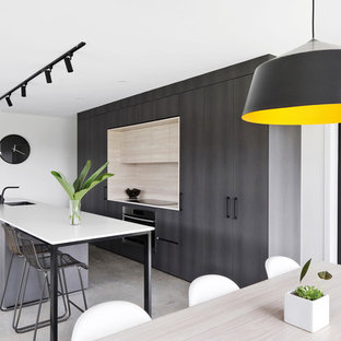 Inspiration for a small contemporary galley eat-in kitchen in Sunshine Coast with a drop-in sink, flat-panel cabinets, beige splashback, timber splashback, stainless steel appliances, concrete floors, multiple islands, grey floor and white benchtop.