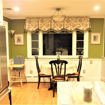 Box pleat valances with a shaped hem and tassel trim in a green kitchen