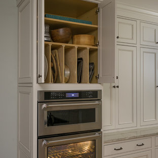 This is an example of a large traditional l-shaped eat-in kitchen in Boston with an undermount sink, recessed-panel cabinets, white cabinets, granite benchtops, grey splashback, glass tile splashback, stainless steel appliances, light hardwood floors, with island and brown floor.