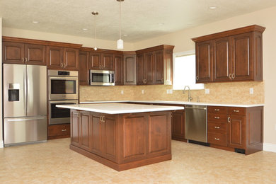 Eat-in kitchen - mid-sized transitional l-shaped beige floor eat-in kitchen idea in Salt Lake City with an undermount sink, raised-panel cabinets, dark wood cabinets, quartz countertops, beige backsplash, stainless steel appliances and an island