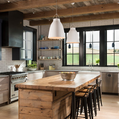 Example of a large cottage l-shaped light wood floor kitchen design in Other with a farmhouse sink, flat-panel cabinets, light wood cabinets, concrete countertops, white backsplash, subway tile backsplash, stainless steel appliances and an island