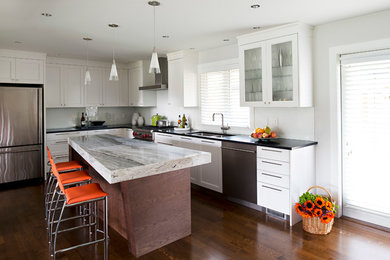 Example of a mid-sized trendy l-shaped medium tone wood floor eat-in kitchen design in Vancouver with an undermount sink, white cabinets, white backsplash and an island