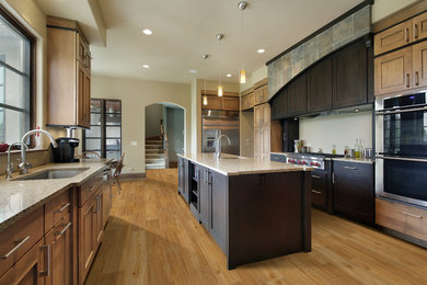 Example of a large trendy galley medium tone wood floor and brown floor eat-in kitchen design in Boston with an undermount sink, shaker cabinets, medium tone wood cabinets, granite countertops, beige backsplash, stainless steel appliances and an island
