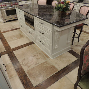 This is an example of a large traditional l-shaped eat-in kitchen in Other with a double-bowl sink, raised-panel cabinets, beige cabinets, granite benchtops, beige splashback, porcelain splashback, panelled appliances, porcelain floors and with island.