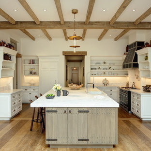 Farmhouse kitchen designs - Inspiration for a cottage light wood floor kitchen remodel in Boston with a farmhouse sink, open cabinets, white cabinets, white backsplash, black appliances, an island and white countertops