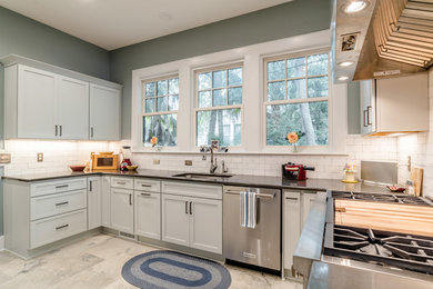 Mid-sized elegant galley porcelain tile enclosed kitchen photo in Miami with an undermount sink, shaker cabinets, gray cabinets, quartz countertops, white backsplash, subway tile backsplash, stainless steel appliances and no island