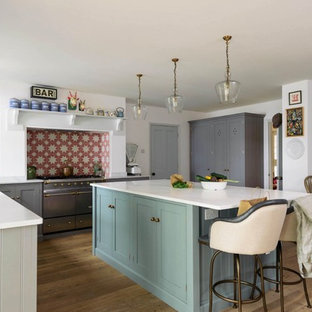 Inspiration for a classic l-shaped kitchen/diner in Hertfordshire with open cabinets, grey cabinets, multi-coloured splashback, stainless steel appliances, medium hardwood flooring, an island and white worktops.