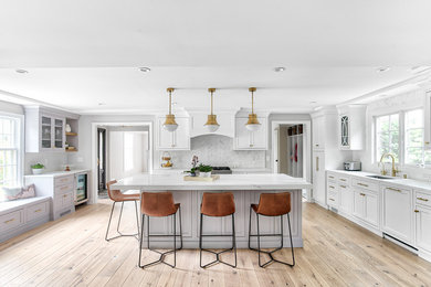 Large transitional u-shaped eat-in kitchen photo in New York with an undermount sink, beaded inset cabinets, white cabinets, quartz countertops, white backsplash, mosaic tile backsplash, paneled appliances, an island and white countertops