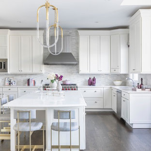 Foto de cocina comedor en U, contemporánea, con fregadero bajoencimera, armarios estilo shaker, puertas de armario blancas, salpicadero de piedra caliza, electrodomésticos de acero inoxidable, suelo de madera oscura, una isla, suelo marrón y encimeras blancas