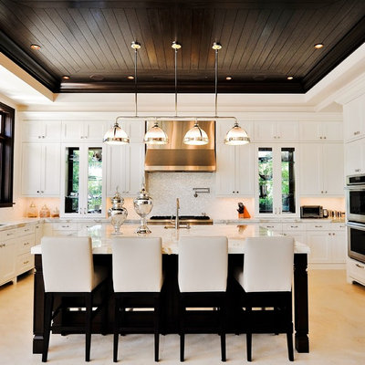 Inspiration for a timeless u-shaped kitchen remodel in Miami with paneled appliances, white cabinets, white backsplash and recessed-panel cabinets
