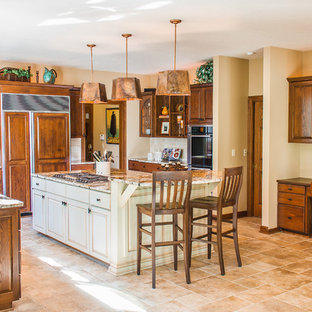 Immagine di una cucina a L chiusa e di medie dimensioni con ante con bugna sagomata, ante in legno scuro, elettrodomestici da incasso, lavello sottopiano, top in granito, paraspruzzi beige, paraspruzzi con piastrelle diamantate, pavimento in travertino, isola e pavimento beige