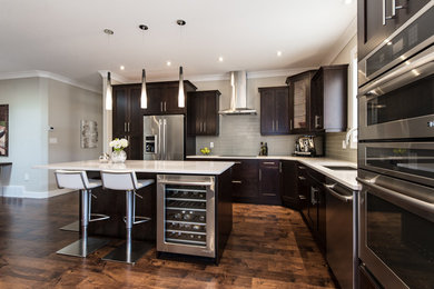 Open concept kitchen - mid-sized transitional l-shaped medium tone wood floor open concept kitchen idea in Vancouver with an undermount sink, shaker cabinets, dark wood cabinets, gray backsplash, glass tile backsplash, stainless steel appliances and an island