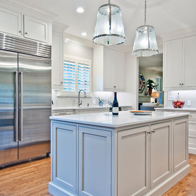 Example of a mid-sized transitional l-shaped medium tone wood floor and brown floor eat-in kitchen design in Nashville with an undermount sink, recessed-panel cabinets, white cabinets, quartz countertops, white backsplash, subway tile backsplash, stainless steel appliances, an island and white countertops