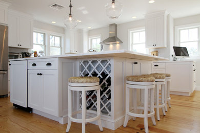Enclosed kitchen - mid-sized coastal l-shaped light wood floor enclosed kitchen idea in Boston with a double-bowl sink, shaker cabinets, white cabinets, marble countertops, stainless steel appliances and an island