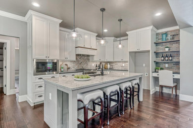 Eat-in kitchen - large transitional u-shaped dark wood floor and brown floor eat-in kitchen idea in St Louis with an undermount sink, shaker cabinets, white cabinets, quartz countertops, beige backsplash, brick backsplash, stainless steel appliances, an island and white countertops