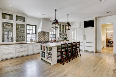 Kitchen - large transitional single-wall light wood floor and brown floor kitchen idea in Houston with a single-bowl sink, glass-front cabinets, white cabinets, multicolored backsplash, porcelain backsplash, stainless steel appliances, an island and brown countertops