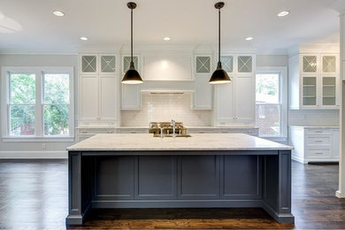 Example of a large transitional single-wall dark wood floor and brown floor kitchen design in Atlanta with a farmhouse sink, shaker cabinets, white cabinets, marble countertops, white backsplash, subway tile backsplash, stainless steel appliances and an island