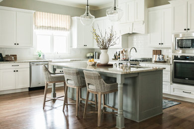 Kitchen - transitional l-shaped dark wood floor and brown floor kitchen idea in Atlanta with a farmhouse sink, shaker cabinets, white cabinets, white backsplash, subway tile backsplash, stainless steel appliances, an island and gray countertops