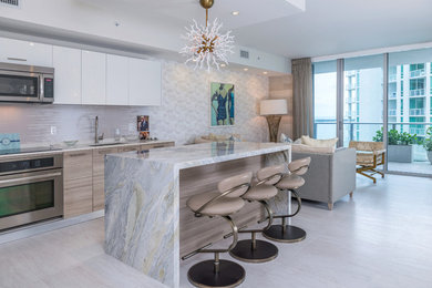 Example of a large eclectic l-shaped ceramic tile and beige floor eat-in kitchen design in Miami with an undermount sink, flat-panel cabinets, white cabinets, multicolored backsplash, stainless steel appliances and an island
