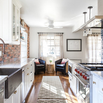 Example of a mid-sized farmhouse galley medium tone wood floor and brown floor eat-in kitchen design in Sacramento with a farmhouse sink, shaker cabinets, white cabinets, quartzite countertops, blue backsplash, ceramic backsplash, stainless steel appliances and an island