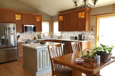 Inspiration for a mid-sized timeless l-shaped light wood floor and beige floor eat-in kitchen remodel in Cedar Rapids with an undermount sink, shaker cabinets, light wood cabinets, quartz countertops, gray backsplash, mosaic tile backsplash, stainless steel appliances and an island