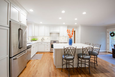 Kitchen - kitchen idea in Bridgeport with recessed-panel cabinets, white cabinets, gray backsplash, an island and white countertops