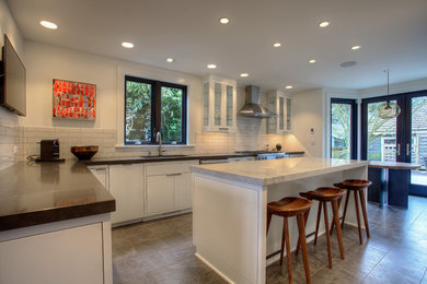 Inspiration for a mid-sized modern u-shaped porcelain tile and gray floor eat-in kitchen remodel in Seattle with an undermount sink, flat-panel cabinets, white cabinets, quartz countertops, white backsplash, subway tile backsplash, stainless steel appliances and an island