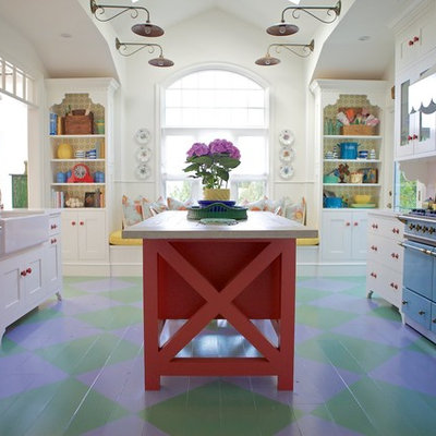Example of a beach style painted wood floor and multicolored floor kitchen design in Los Angeles with a farmhouse sink, white cabinets, quartz countertops, ceramic backsplash, an island and colored appliances